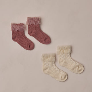 Noralee Ruffle Socks - Ivory / Raspberry 
Two pairs of knitted socks, one pink and one beige, on a beige background.