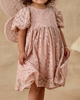 Noralee Luna Dress - Rose Embroidered Daisy
Child wearing a pink floral dress with butterfly wings against a beige background