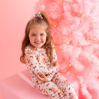 Posh Peanut Classic Pajama Set - Ginger Posh
Young girl in a teddy bear-themed outfit sitting in front of a pink Christmas tree.