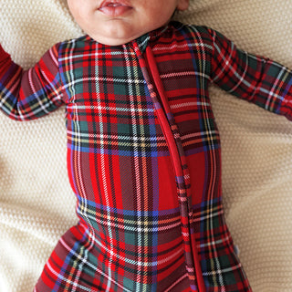 Posh Peanut Footie Zippered One Piece - Red Tartan Plaid
Baby wearing a red and green plaid outfit on a beige surface