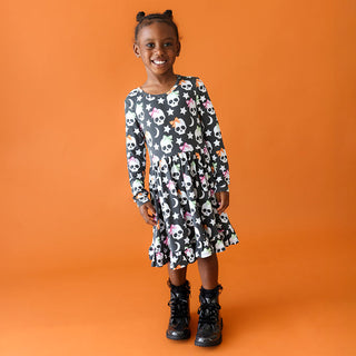 Posh Peanut Kelly Skelly Glow in the Dark Twirl Dress
Young girl wearing a patterned dress on an orange background