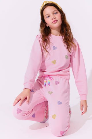 Lola and The Boys Pink Crystal Hearts Set
Young girl wearing a pink pajama set with heart patterns on a white background