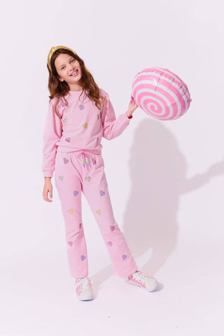 Lola and The Boys Pink Crystal Hearts Set
Young girl in pink outfit holding a pink and white striped ball on a light pink background