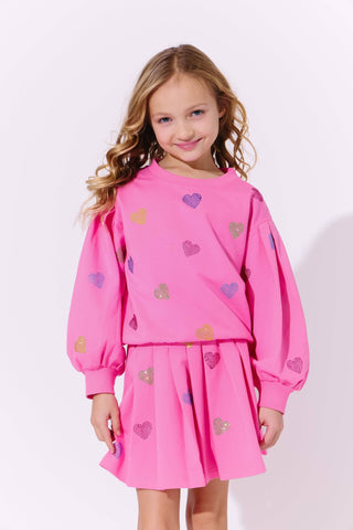 Lola and The Boys Hot Pink Sparkle Hearts Skirt Set
Young girl wearing a pink outfit with heart patterns on a white background