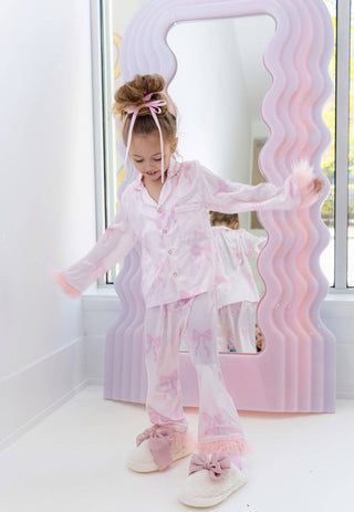 Lola and The Boys Kid's Pretty in Bows Silky Set Young girl in a pink outfit standing in front of a decorative mirror.