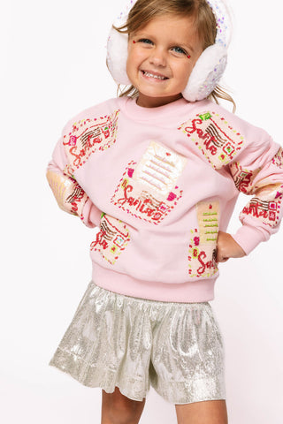 Princess of Sparkles Queen of Sparkles KIDS Letters to Santa - Pink  
Child wearing a pink sweater with colorful designs and white earmuffs on a white background