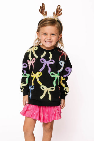 Princess of Sparkles Queen of Sparkles KIDS Multi Bow Sweatshirt - Black
Child wearing a black sweater with colorful bows and a pink skirt, smiling on a white background.