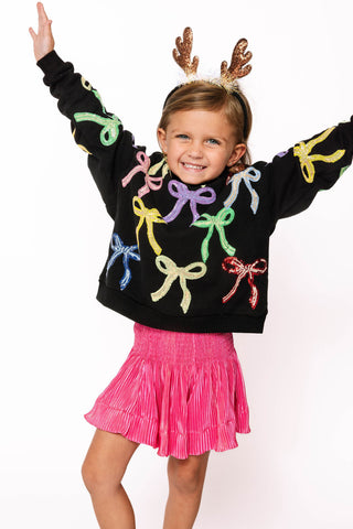 Princess of Sparkles Queen of Sparkles KIDS Multi Bow Sweatshirt - Black
Child wearing a black sweater with colorful bows and a pink skirt, standing against a white background.