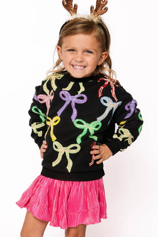 Princess of Sparkles Queen of Sparkles KIDS Multi Bow Sweatshirt - Black 
Child wearing a black sweater with colorful bows and a pink skirt on a white background
