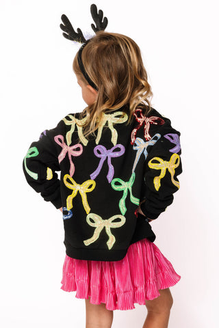 Princess of Sparkles Queen of Sparkles KIDS Multi Bow Sweatshirt - Black
Person wearing a black sweater with colorful bows and pink skirt on a white background