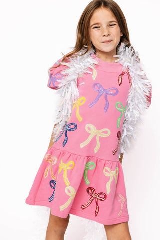 Princess of Sparkles Queen of Sparkles KIDS Sequin Multi Bow With Poof Sleeve Dress
Young girl wearing a pink dress with colorful bow patterns and a white feather boa.