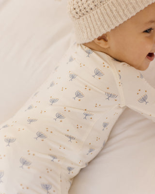 Quincy Mae Bamboo Zip Footie - Hanukkah
Baby wearing a cream-colored sleeping bag with subtle patterns and a matching hat.