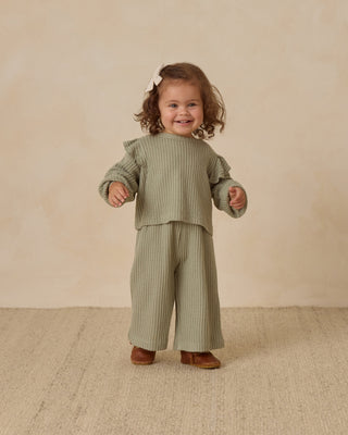 Quincy Mae Ruffle Cozy Set - Fern
Child wearing a green outfit with ruffled sleeves on a beige background