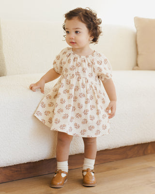 Quincy Mae Bella Dress - Daylily
Child wearing a floral dress standing in front of a white couch.
