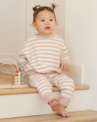 Quincy Mae Relaxed Sweatshirt & Relaxed Sweatpant Set - Pink Stripe
Baby in pink and white striped outfit sitting on a wooden step with toys in the background