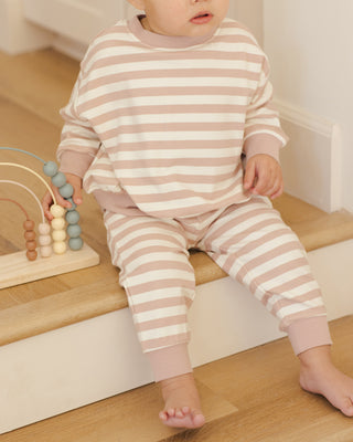 Quincy Mae Relaxed Sweatshirt & Relaxed Sweatpant Set - Pink Stripe
Child wearing pink and white striped pajamas sitting on a wooden step.
