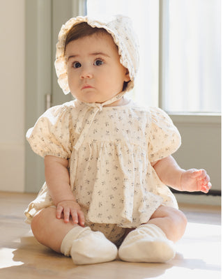 Quincy Mae Francy Set - Bluebell 
Baby in a white floral outfit sitting on a wooden floor.