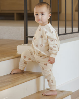 Quincy Mae Relaxed Sweatshirt & Relaxed Sweatpant Set - Brown Bear
Baby in a cream-colored outfit with small patterns standing on a staircase.
