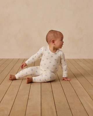 Quincy Mae Bamboo Pajama Set - Hanukkah
Baby sitting on a wooden floor wearing a white onesie with blue patterns.