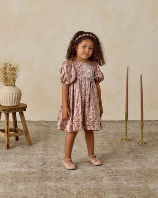 Noralee Luna Dress - Harvest Fleur
Young girl in a floral dress standing in a room with wooden floor and decorative elements.