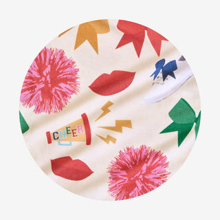 Posh Peanut Sabrina Criss-Cross Twirl Dress Circular fabric with colorful patterns including pom-poms, lips, and a cheerleading megaphone on a white background.
