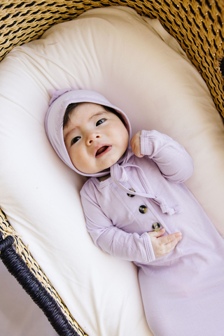 Lou Lou and Company Knotted Gown - Isabelle
Baby in a purple outfit lying on a white cushion inside a wicker basket