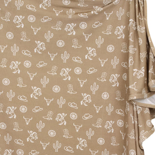 Lou Lou and Company Swaddle Blanket - Wyatt
Beige fabric with white western pattern including cacti, boots, and horses.