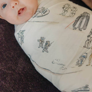 Copper Pearl Star Wars Tatooine™ Swaddle Blanket
Baby wearing a Star Wars-themed onesie on a dark surface