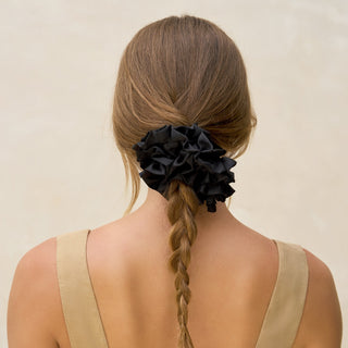 Kitsch Black Ruffle Scrunchie
Person with braided hair tied with a black scrunchie against a beige background