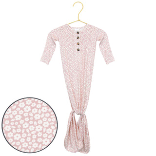 Lou Lou and Company Knotted Gown - Flora
Pink floral baby onesie on a hanger with close-up of fabric pattern.