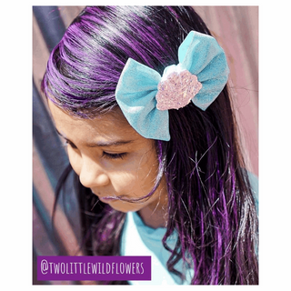 Hair Coloring Chalk - 12 Pack Set
Child with purple hair wearing a blue bow headband, with 'Two Little Wildflowers' branding.