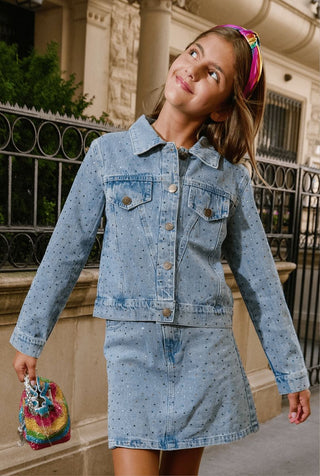 Lola and The Boys Rainbow Sparkle Denim Jacket
Girl wearing a denim outfit with a colorful headband and purse, standing outdoors.