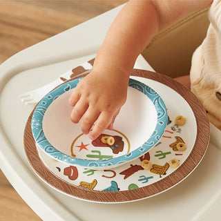 Itzy Ritzy Itzy Bistro™ Dining Set - Giddy Up
Child's hand reaching for a colorful plate with animal illustrations on a wooden surface.