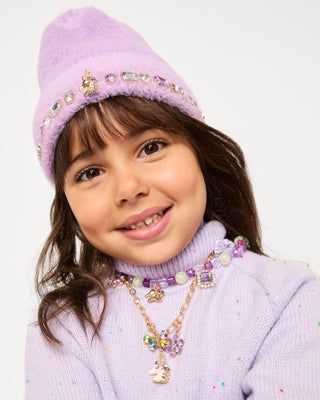Super Smalls Lavender Dreams Beanie
Young girl wearing a purple outfit with decorative elements on a white background