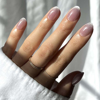 Glamnetic Press-On Nails Short Round - Fairy Dust
Hand with pink nail polish and a gold ring on a white background
