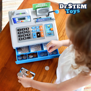 Dr. Stem Talking Cash Register Playset
A child's toy cash register playset on a wooden table, with a child's hands interacting with the blue drawer and coins. The Dr.
