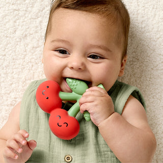 Itzy Ritzy Comfort Crew cherry-themed teether featuring a soft silicone surface and colorful cherry design for soothing babies.