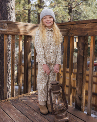 Rylee & Cru Denim Chore Coat - Leopard
A young girl stands on a wooden deck wearing a beige and brown animal-print hooded one-piece outfit, a gray knit beanie, and tan boots, holding a vintage-style lantern. Trees and a wooden fence are visible in the background.
