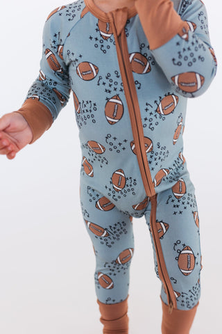 In My Jammers Green Football Zipper Romper
Baby in a blue onesie with football pattern and brown boots on a white background