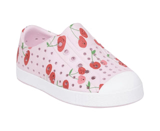 Native Jefferson Print Shoes - Barely Pink / Shell White / Cherries
A single pink slip-on clog shoe with a red cherry and green stem pattern on the upper, featuring a white rubber toe cap and sole, shown against a light gray background.