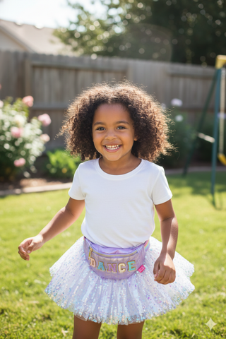 Great Pretenders Dance Fanny Pack
Child wearing a white t-shirt and colorful skirt with 'Dance' written on it, standing in a backyard.