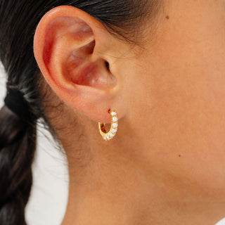 Pip Pop Post Earrings - Opal Hoop
Close-up of an ear wearing a gold hoop earring with a blurred background
