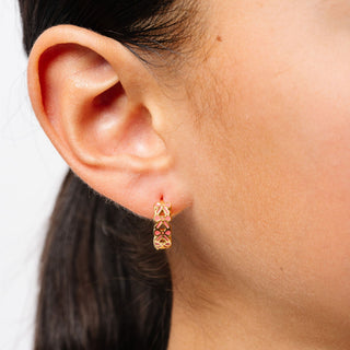 Pip Pop Post Earrings - Bow Repeat Hoop
Close-up of an ear wearing a gold hoop earring with a blurred background
