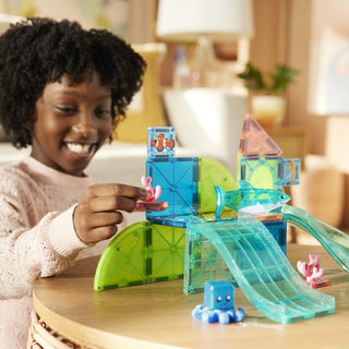 Magna-Tiles Coral Reef™ 25-Piece Set (Copy)
Child playing with a transparent toy set on a table, smiling.