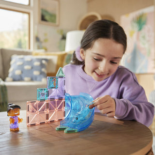 Magna-Tiles Dolphin Bay™ 13-Piece Set
Child playing with a blue toy fish and castle set on a table in a living room.