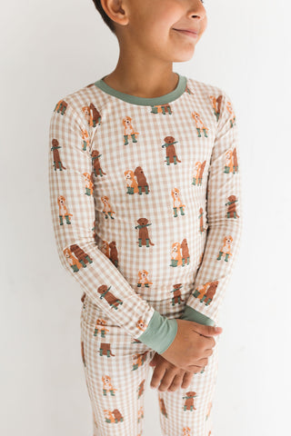 In My Jammers Two Piece Set - Green Pup Friends
Child wearing a pajama set with bear pattern on a plain background