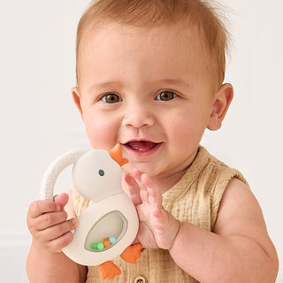 Itzy Ritzy Bitzy Shake silicone teether with rattle in goose color, featuring soft silicone and a cheerful rattling toy for babies.