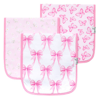Copper Pearl Burp Cloth Set - Bow My Gosh
Three square baby bibs with rounded bottom corners, featuring pink and white patterns. The front bib has a repeating pink bow pattern on a white background, the middle bib has a light pink daisy pattern, and the back bib has a pink butterfly pattern.