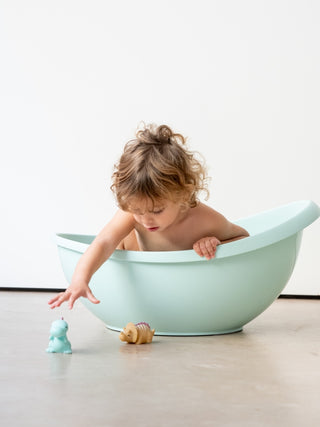 Kalencom Happy Dinos Bath Toys
Child playing in a light blue bathtub with toys on a white background