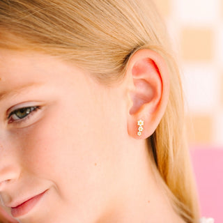 Pierced Co. Daisy Crawler Earrings
Close-up of a young girl wearing a gold earring with star designs.